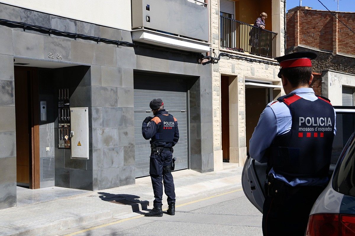 Dos agents dels mossos d'esquadra instants abans de treure la dona detinguda després del registre a La Guixa
