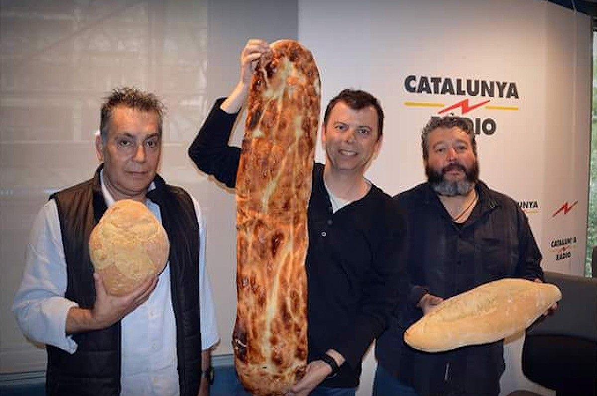 Mauri, Martínez Castro i Pla mostren el pa i la coca artesanal del Lluçanès.