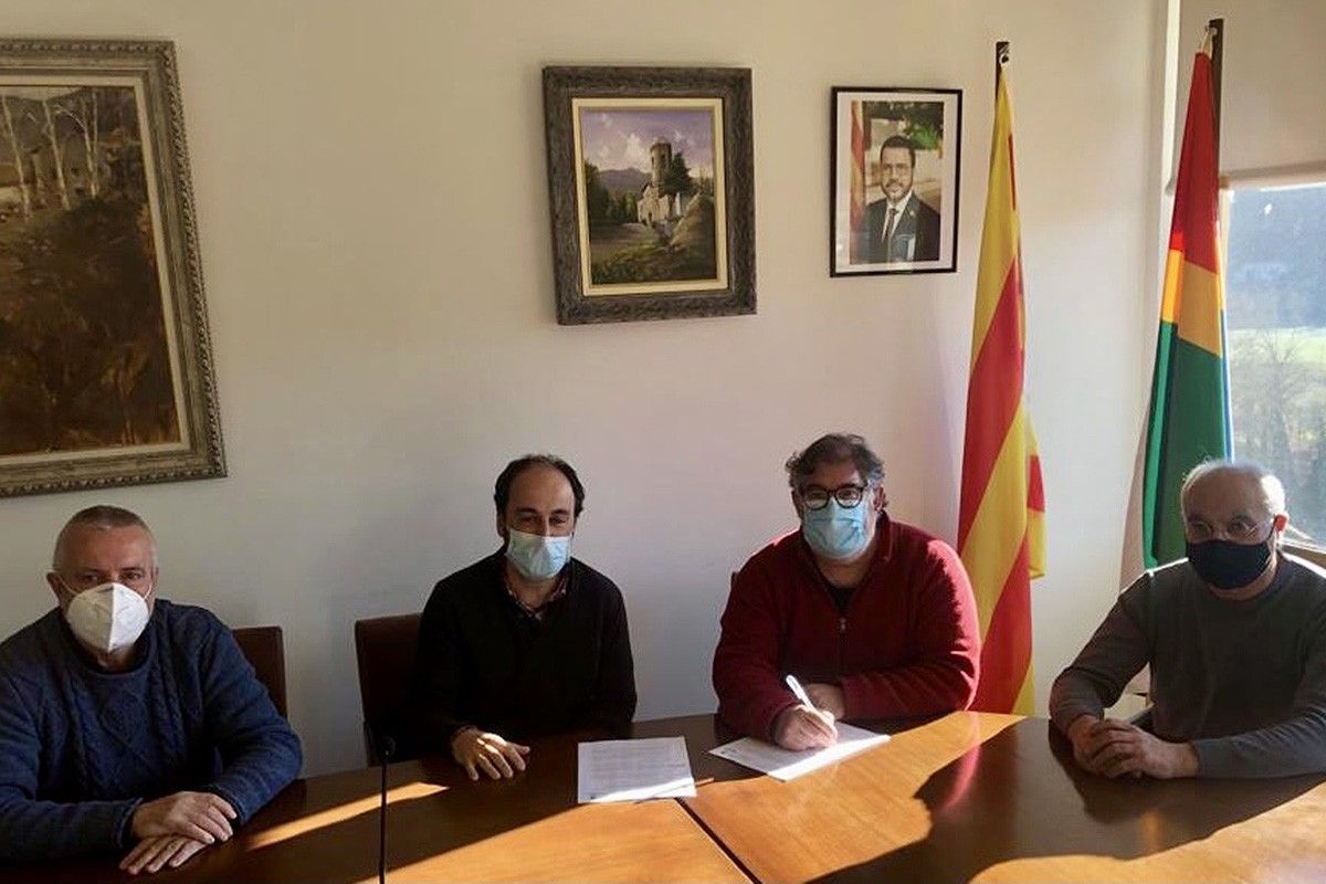 Representants de l'Ajuntament de l'Esquirol i la Vall d'en Bas signant l'acord.