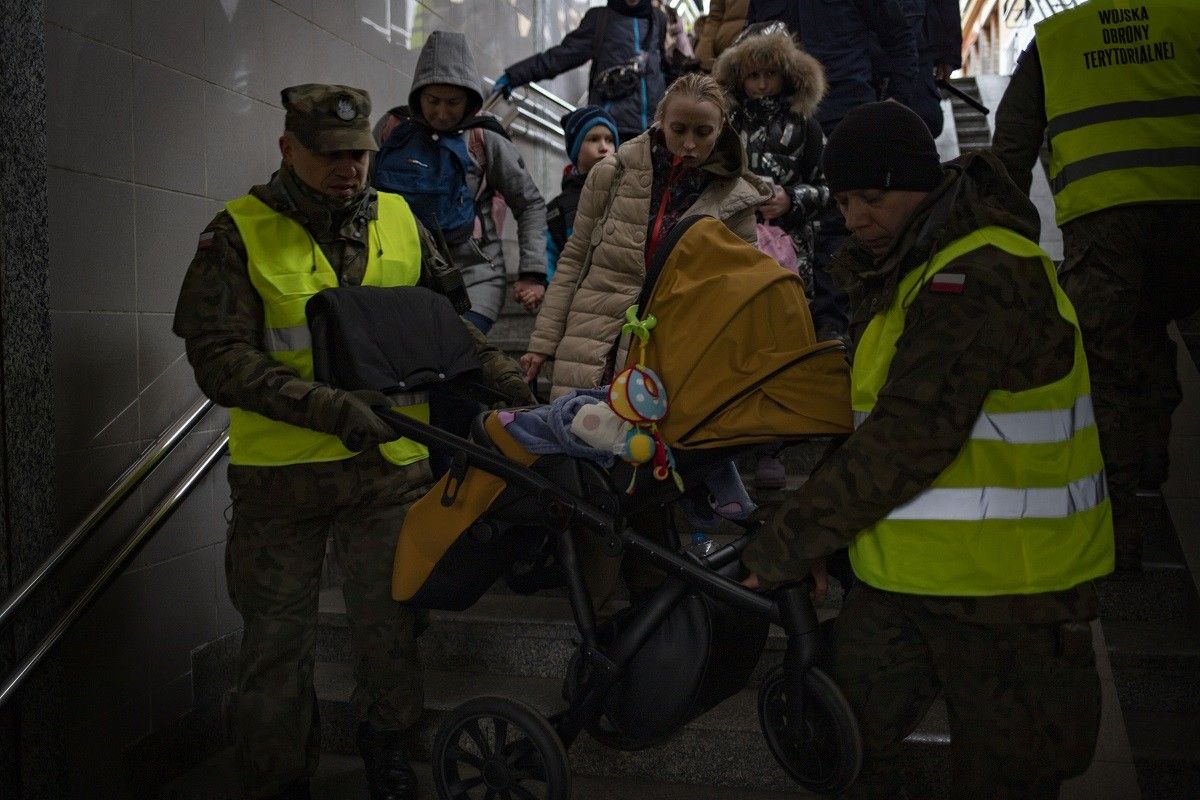 Soldats de l'exèrcit polonès ajuden a les persones refugiades a l'estació de Przemyśl