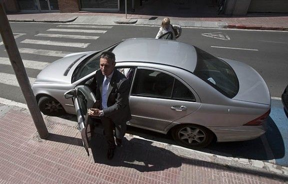 Josep Anglada sortint del seu cotxe aparcat en zona de minusvàlids, aquest migdia davant del col·legi Sant Miquel.