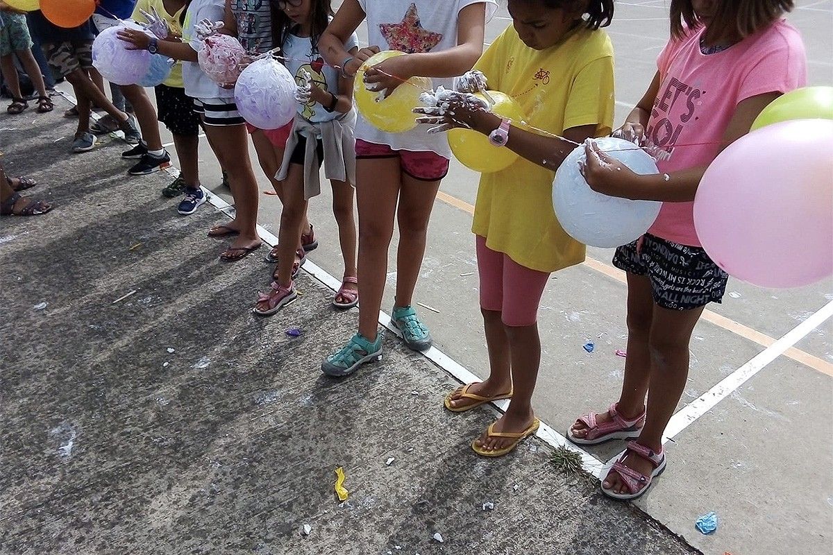 Infants participant en una activitat d'estiu a Vic.