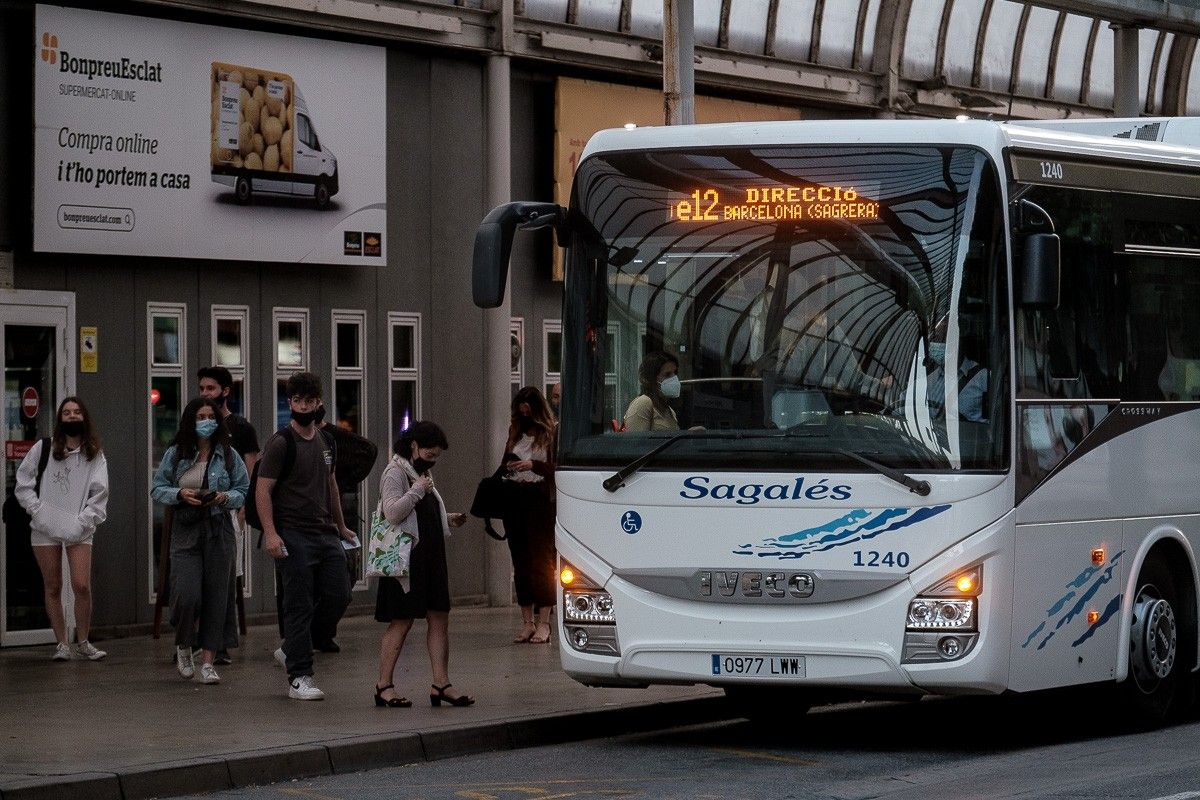 Usuaris de la línia e12 agafant el bus a l'estació de Vic.