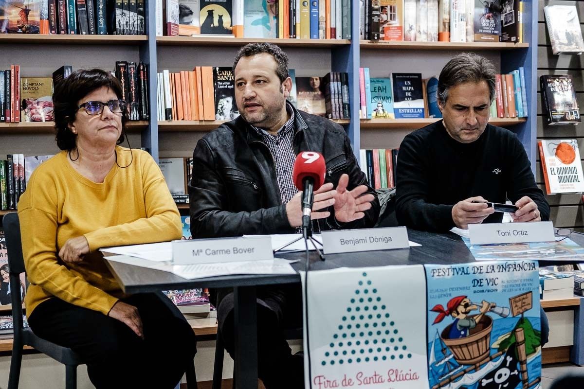 Maria Carme Bover, Benjamí Dòniga i Toni Ortiz a la roda de premsa de presentació de la Fira de Santa Llúcia i el Festival de la Infància de Vic que s'ha fet al Cafè de Lletres.