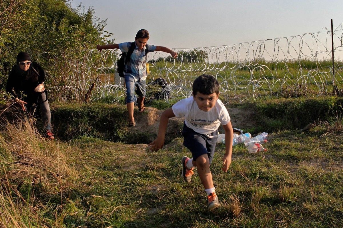 Una família de refugiats sirians salta la valla d'Hongria.