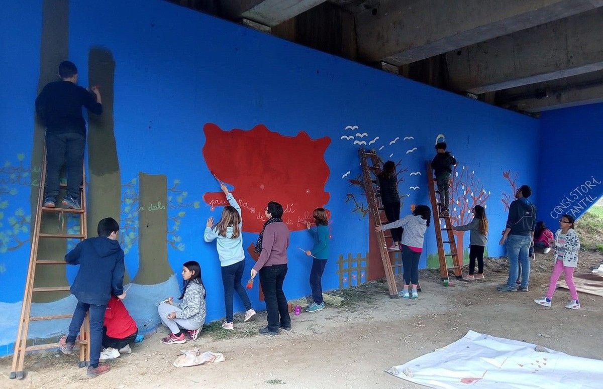 Els alumnes de sisè de Torelló pintant el mural, divendres passat.