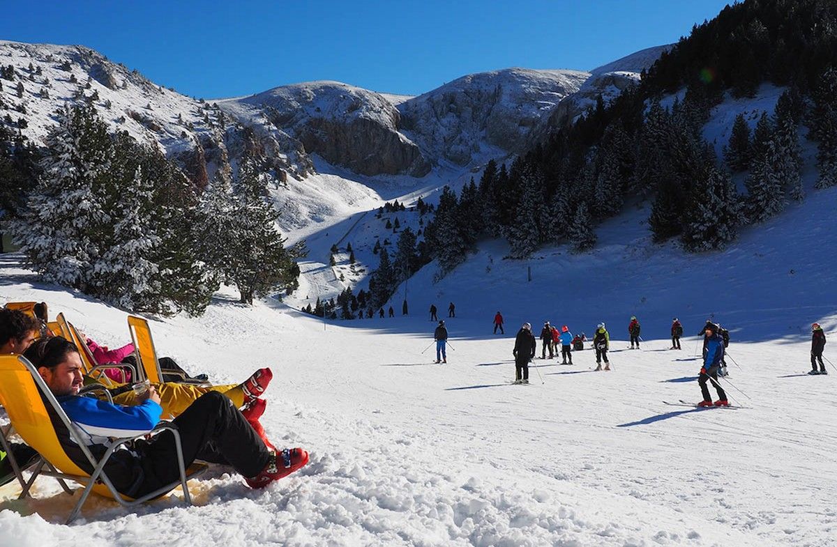 Uns esquiadors descansen mirant les pistes