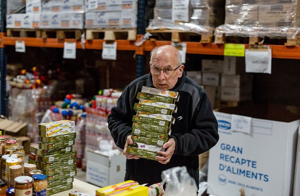 Un voluntari, classificant els productes recollits a El Sarró, el Banc d'Aliments de Manlleu