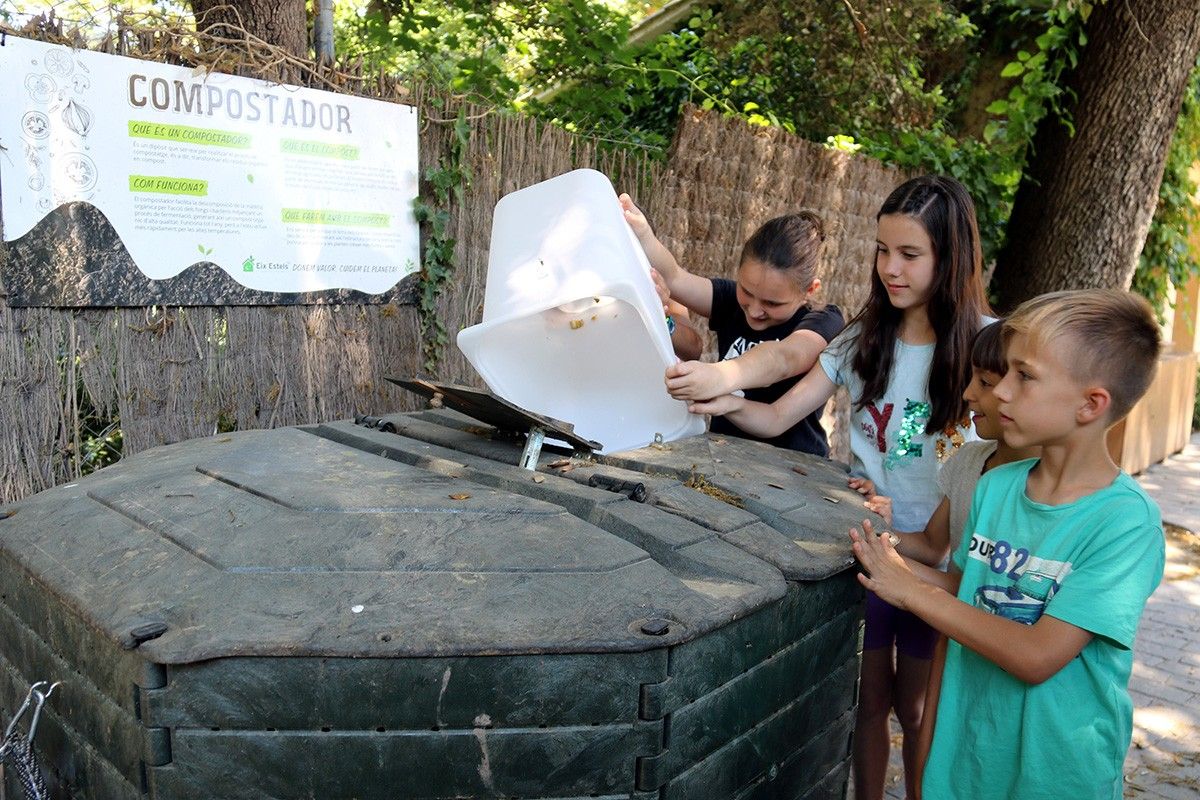 Els escolars llençant els residus orgànics a la compostadora.