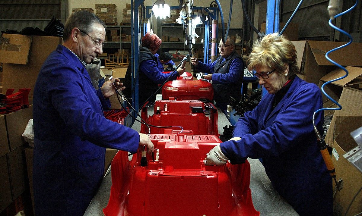 Treballadors d'una fàbrica de joguines a Ibi, en el procés de fabricació d'un cotxe de joguina.