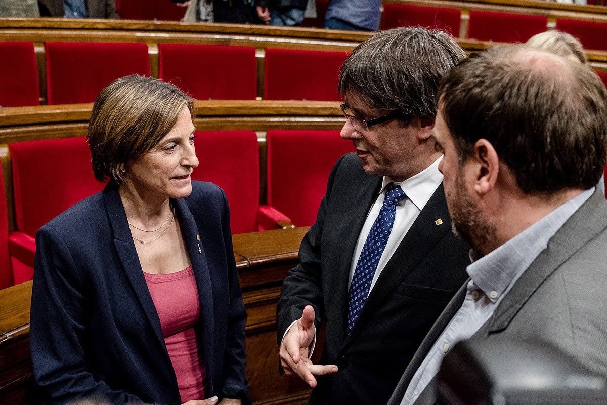 Carme Forcadell conversa amb Carles Puigdemont i Oriol Junqueras en una imatge d'arxiu al Parlament
