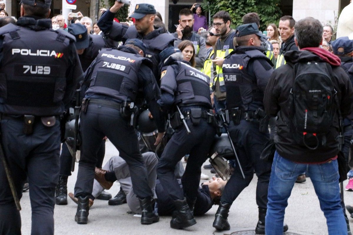 Un votant és reprimit a terra per forces de la policia espanyola en un centre electoral a Girona durant l'1 d'cotubre.