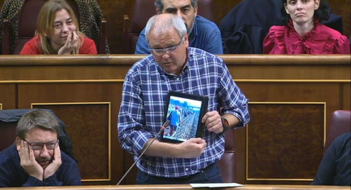 El diputat d'En Comú Podem Fèlix Alonso, mostrant la imatge d'una usuària de Renfe junt a les vies.