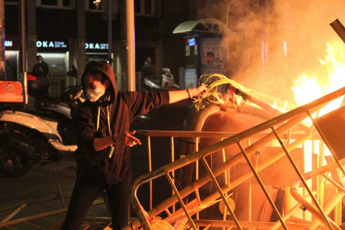 Una manifestant cou calçots en una barricada a tocar de la plaça Lesseps de Barcelona