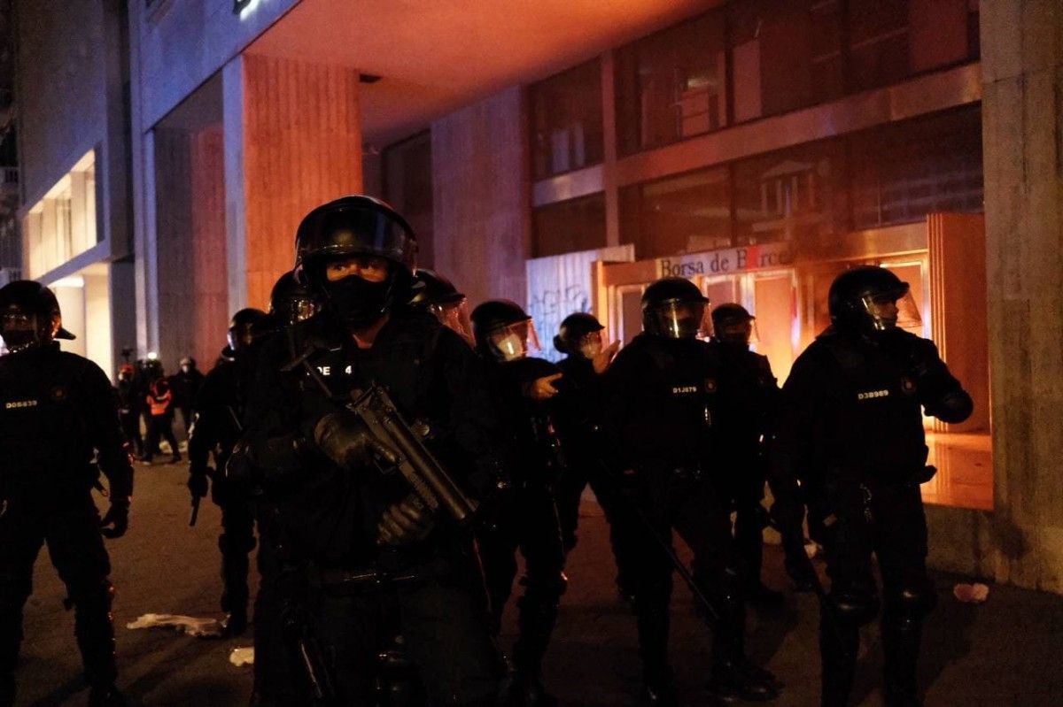 Agents dels Mossos davant de la Borsa de Barcelona, on un grup de manifestants hi ha calat foc