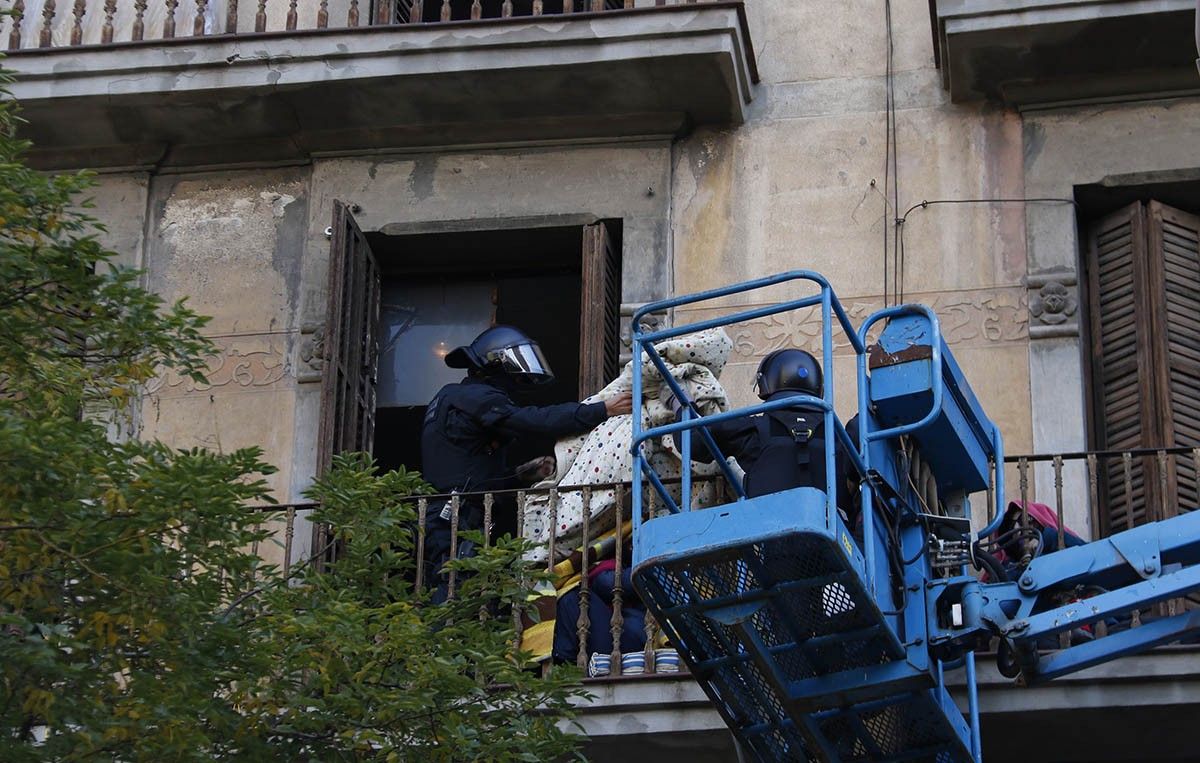 Desallotjament de l'edifici, amb dos agents de la Guàrdia Urbana en un dels balcons