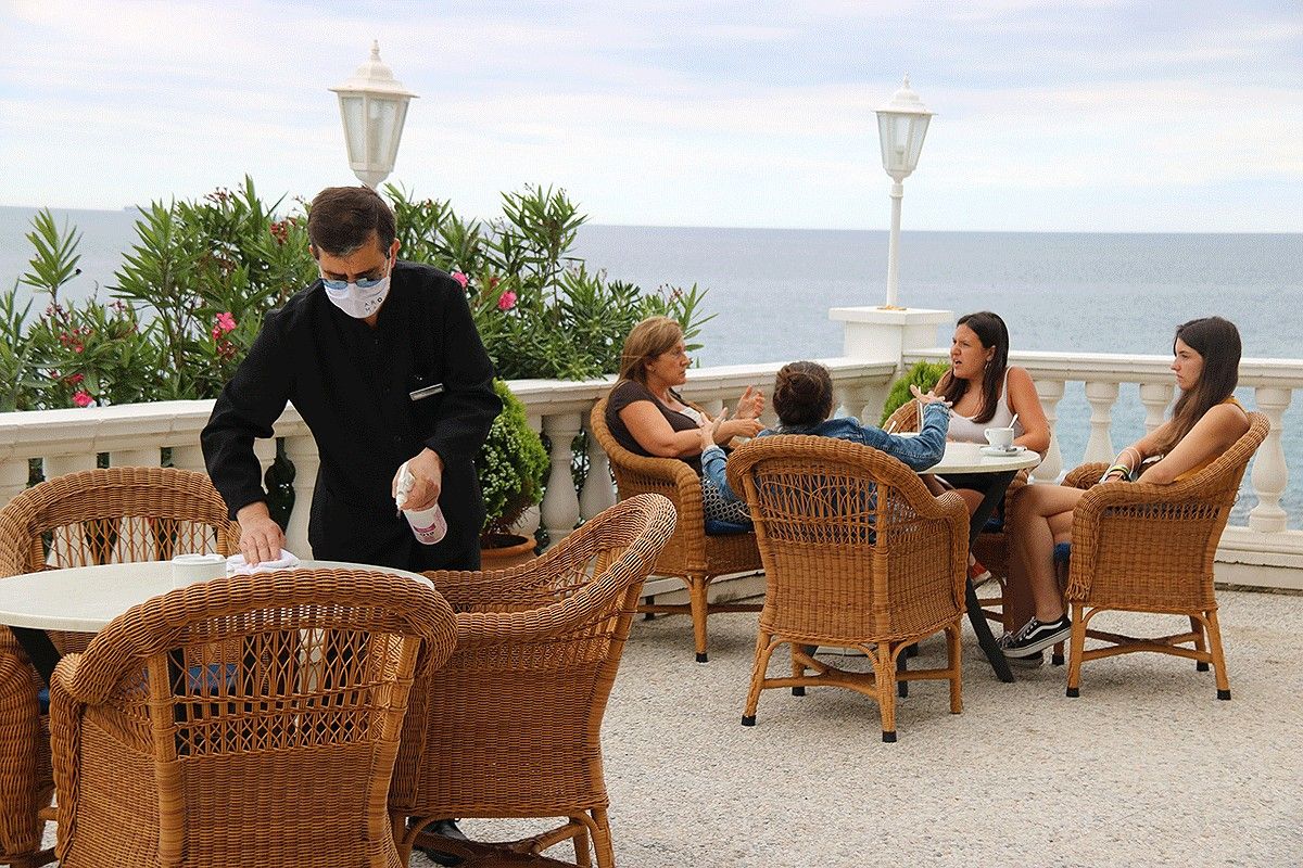 Un cambrer, netejant una taula d'un hotel de la Costa Brava