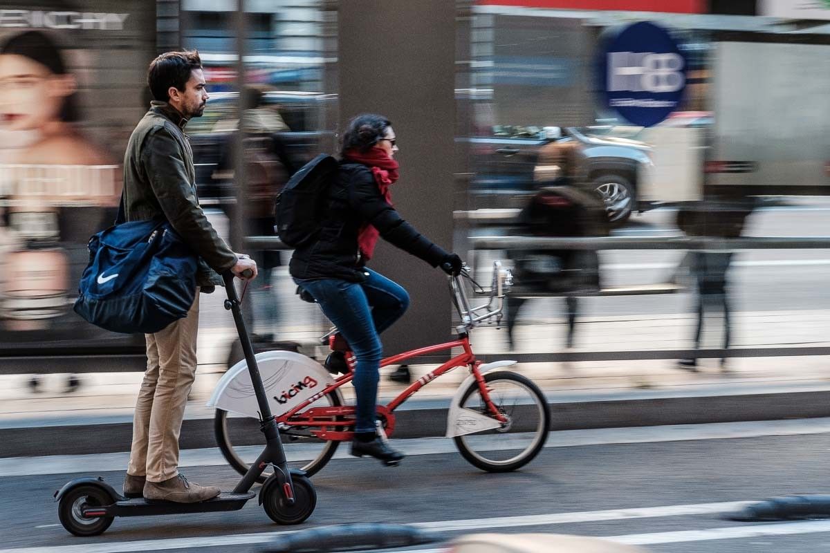 Un patinet elèctric i una bicicleta compartint el carril a Barcelona.
