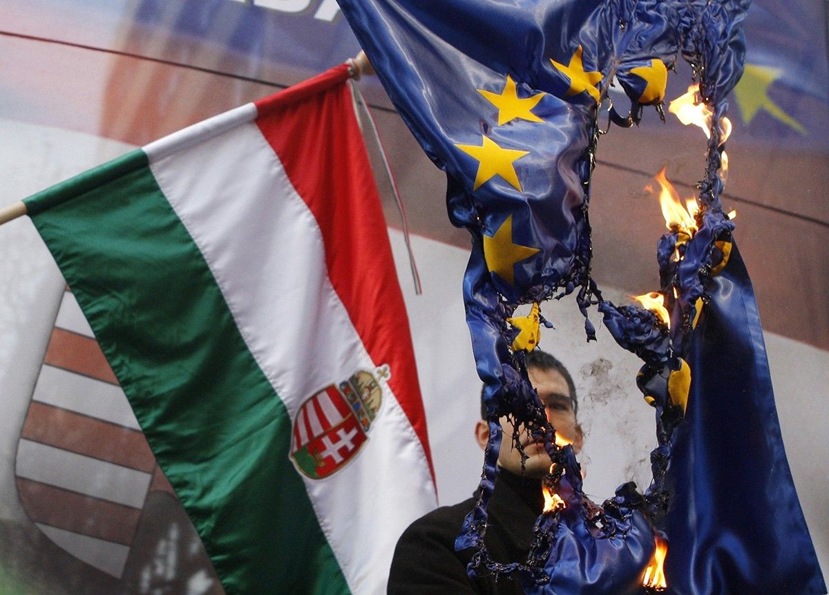 Un membre del partit d'extrema dreta d'Hongria crema una bandera de la Unió Europea a Budapest
