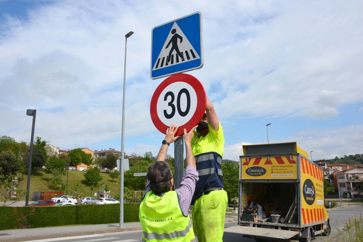 Operaris canvien senyals de trànsit a Olot, en una imatge d'arxiu