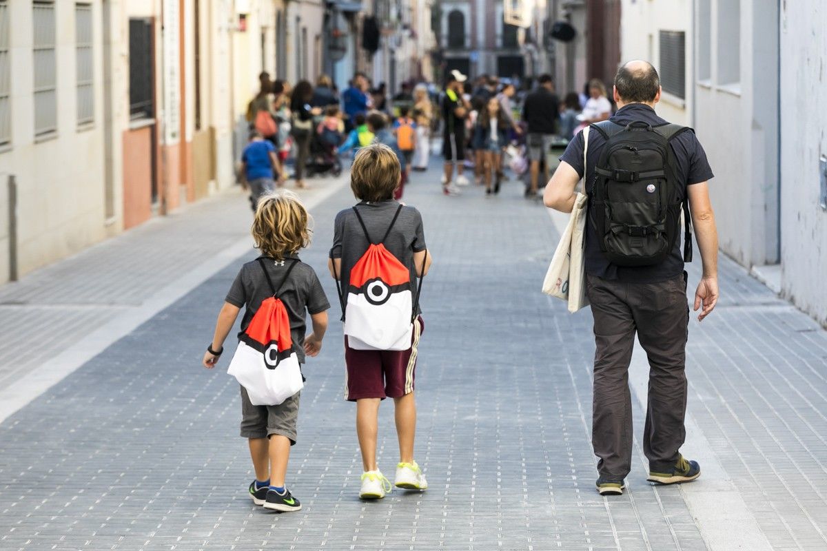 Un pare acompanya els seus fills a Ciutadans amb mascareta, a Barcelona.