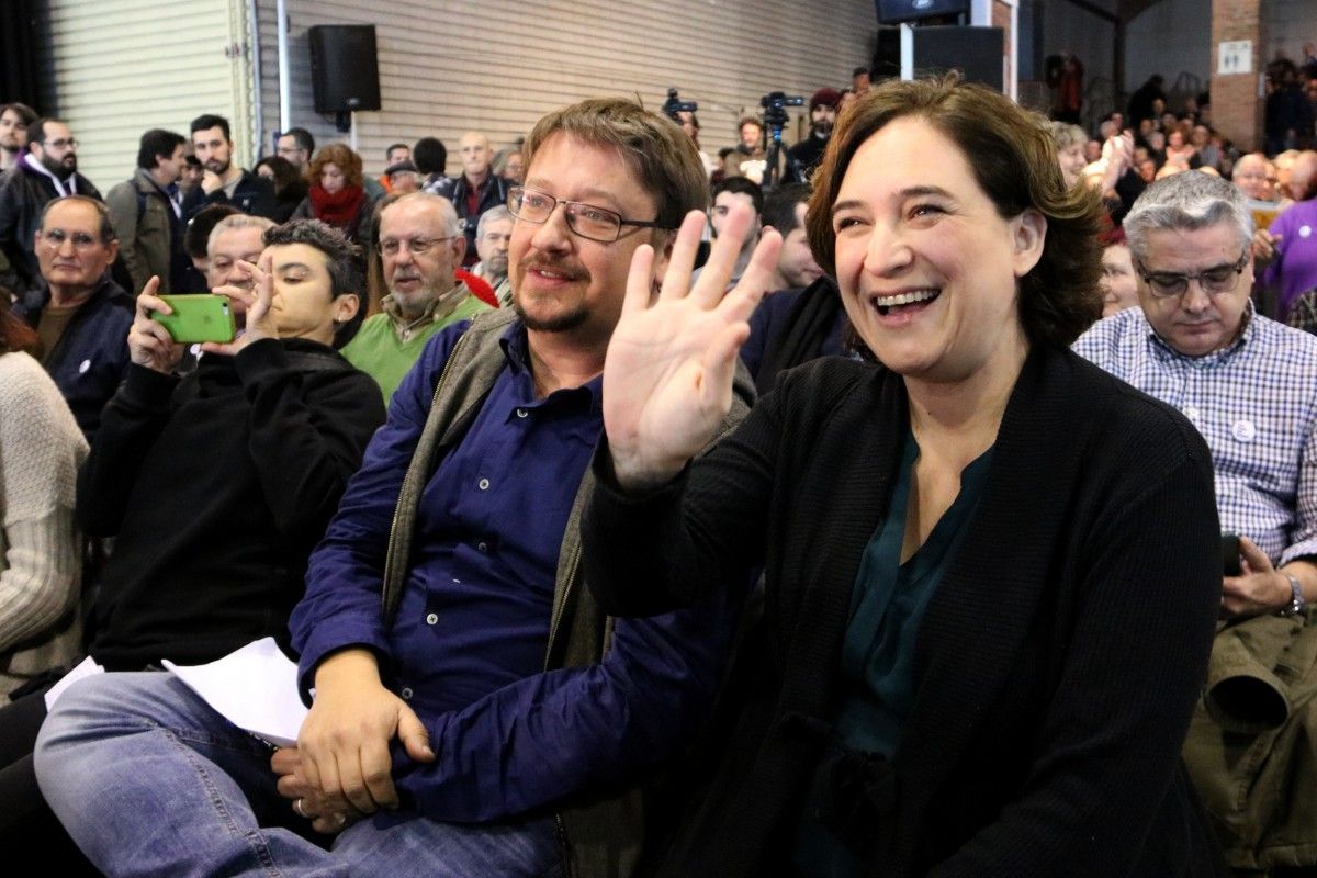 Ada Colau saluda al costat del cap de llista d'En Comú Podem, Xavier Domènech, a l'acte dels comuns a Cotxeres de Sants