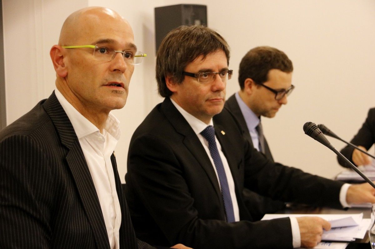 Carles Puigdemont, acompanyat de Raül Romeva i Albert Royo, dos dels investigats en la causa contra l'acció exterior de la Generalitat