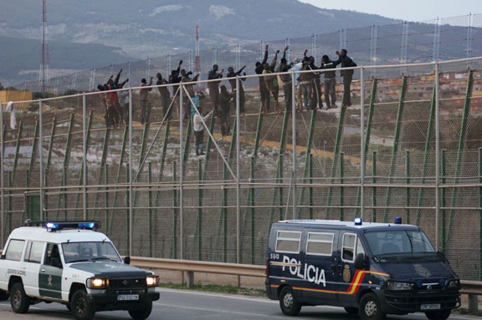 Grups d'immigrants,  dalt la tanca de Melilla, al costat marroquí.