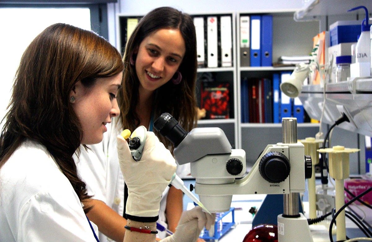 Dues dones científiques conversen en una laboratori