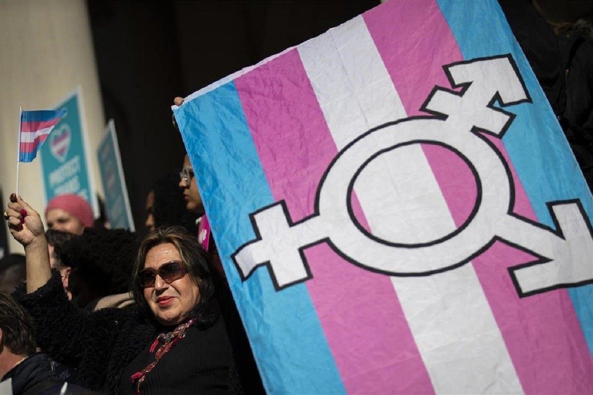Una dona amb la bandera representativa del col·lectiu trans