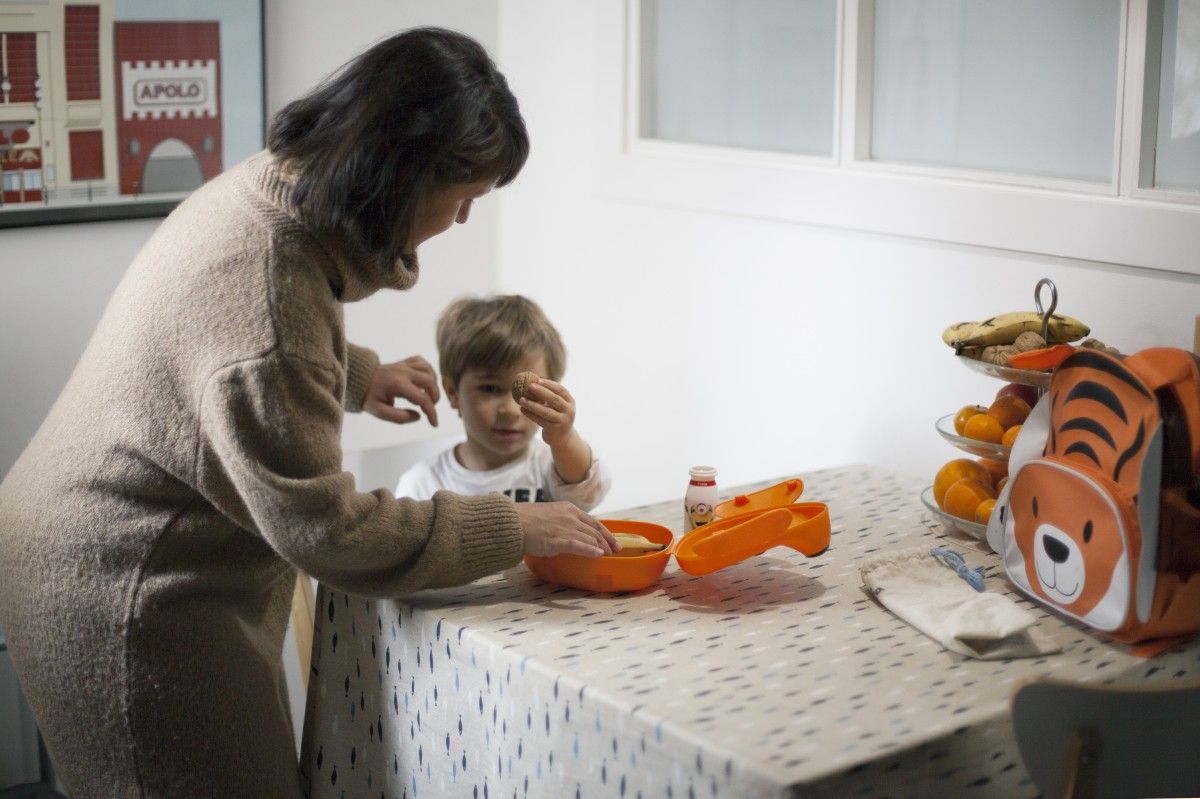 Una mare donant l'esmorzar al seu fill
