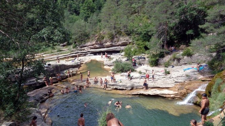 Banyistes a la Riera de Merlès durant un cap de setmana d'estiu