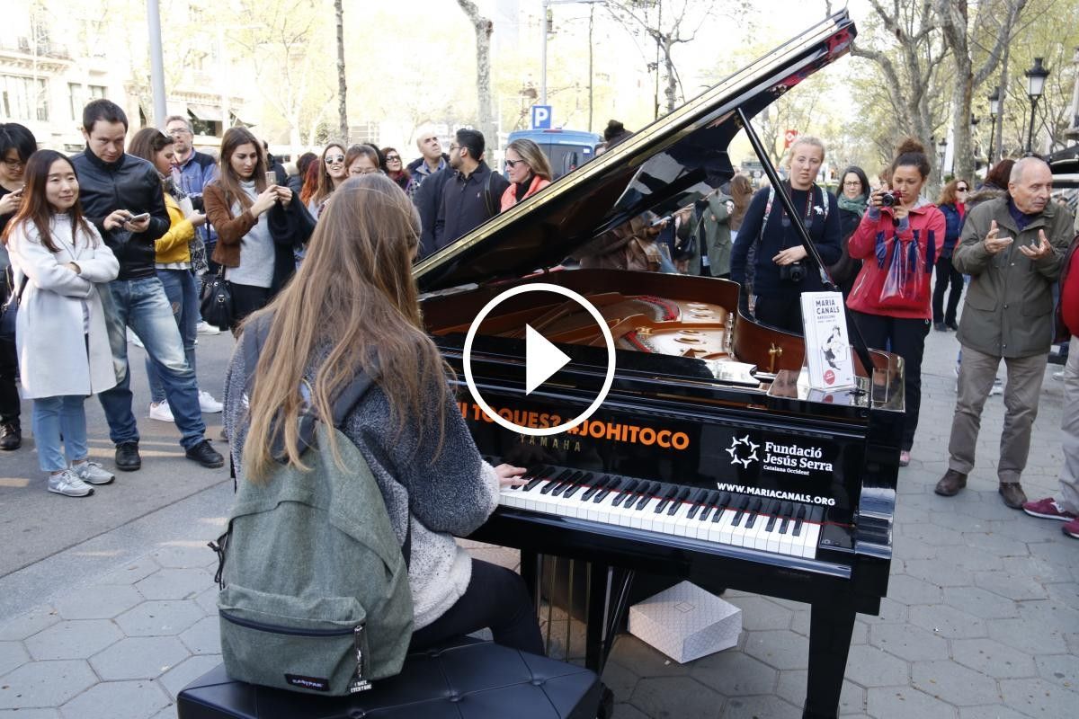Una noia toca el piano davant de la Casa Batlló al passeig de Gràcia de Barcelona