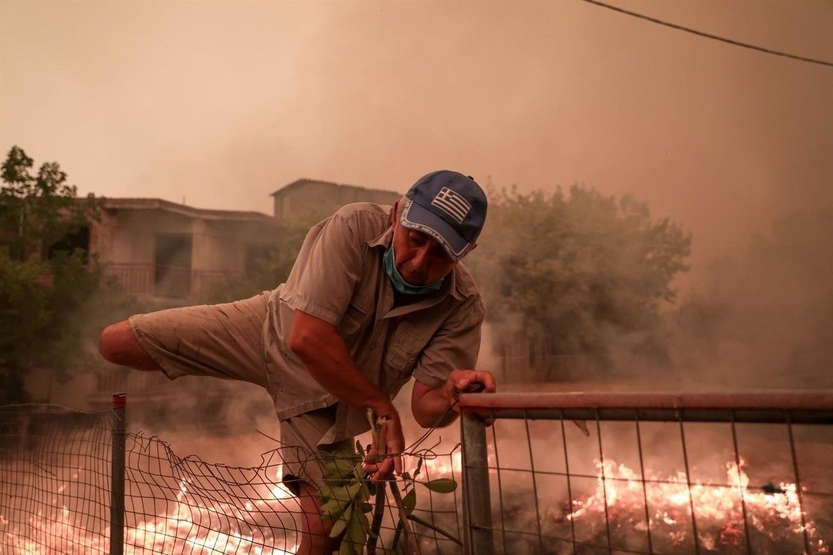 Un home escapa de les flames a Grècia.