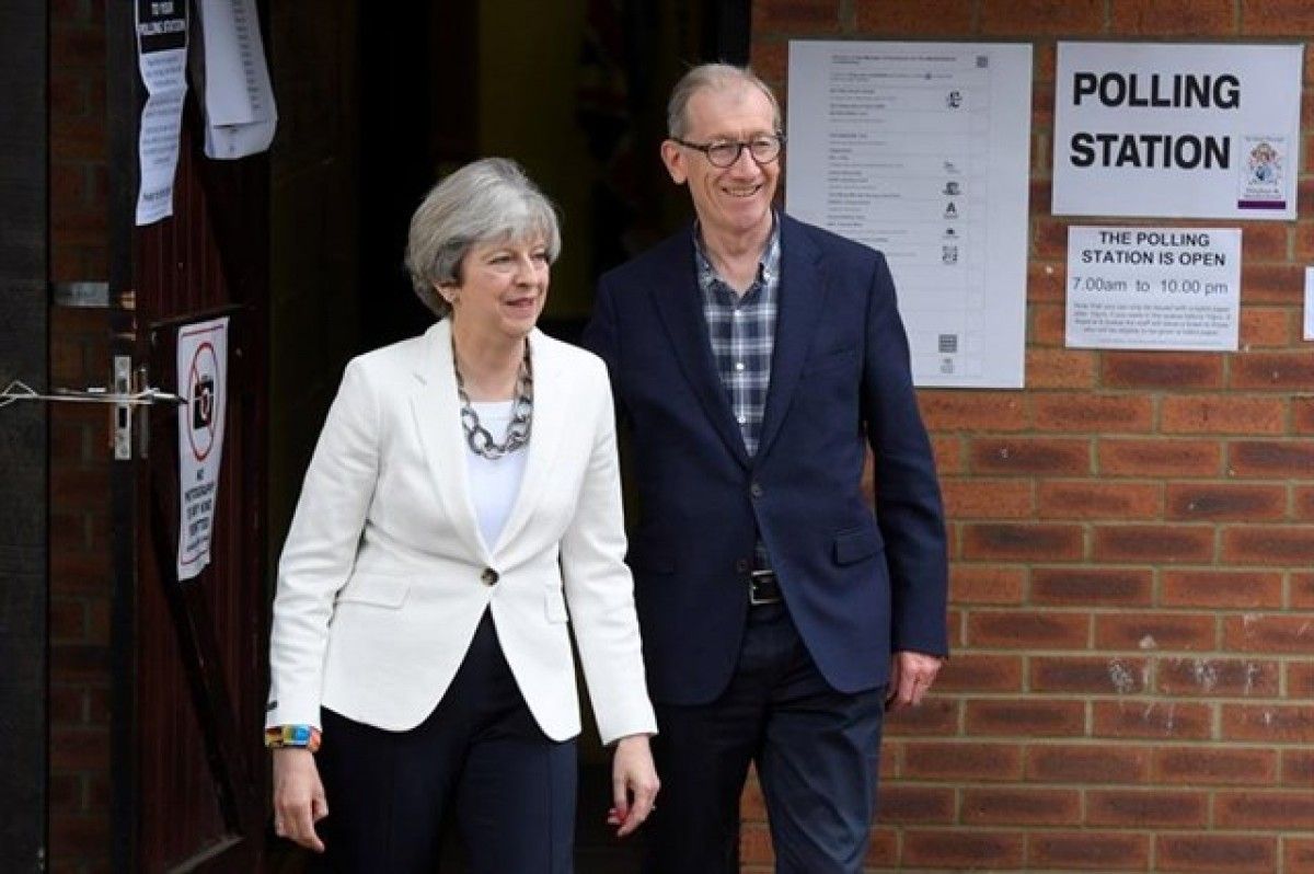 Theresa May surt de votar acompanyada del seu marit