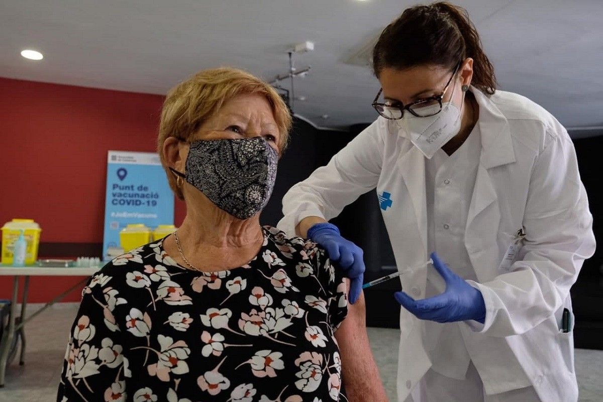 Una sanitària vacuna una dona contra la Covid