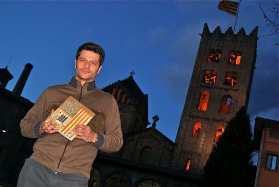 Joel Joan, amb el seu llibre, davant el Monestir de Ripoll.