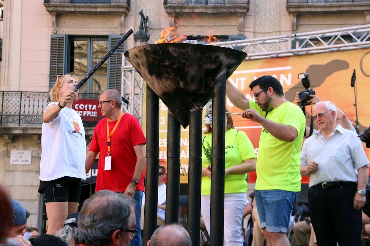 La Flama del Canigó encenent el peveter de la plaça de Sant Jaume de Barcelona