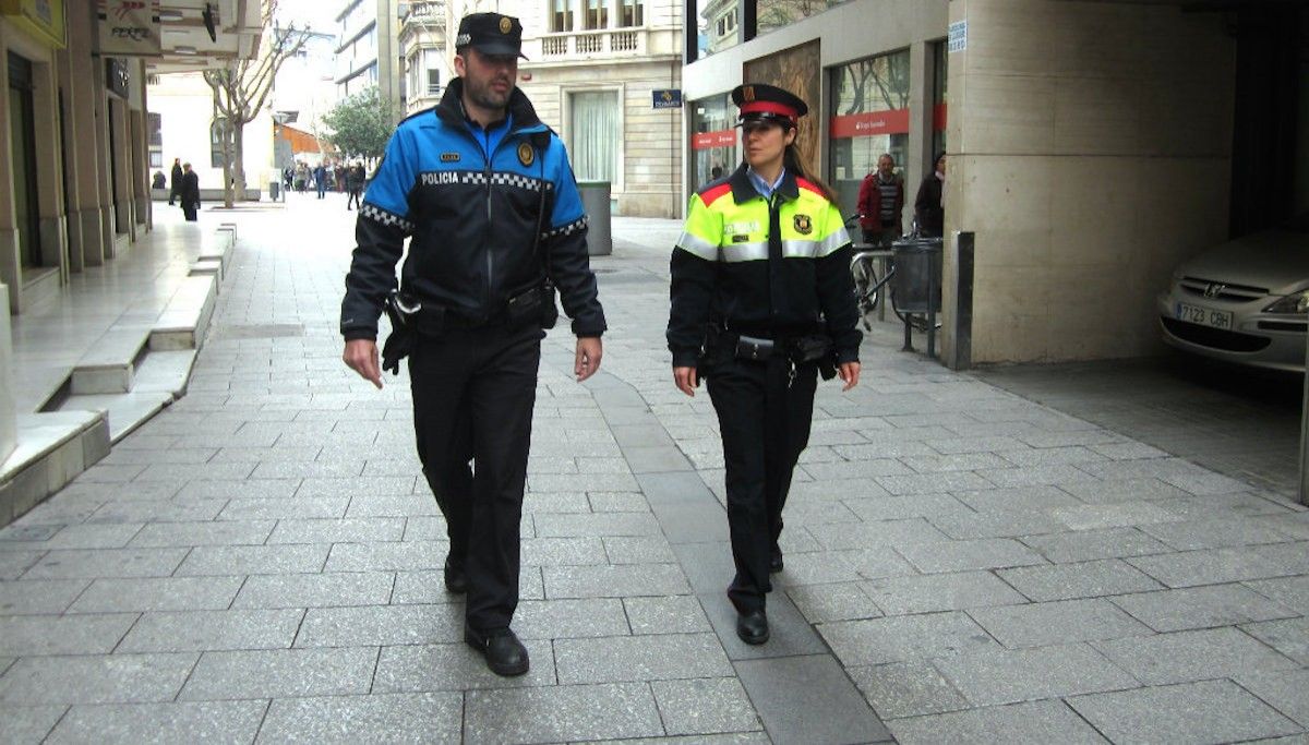 Dos agents de la Policia Municipal i dels Mossos d'Esquadra al centre.