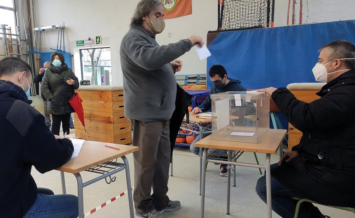 Un home votant en una mesa habilitada al gimnàs de l'institut Vallès