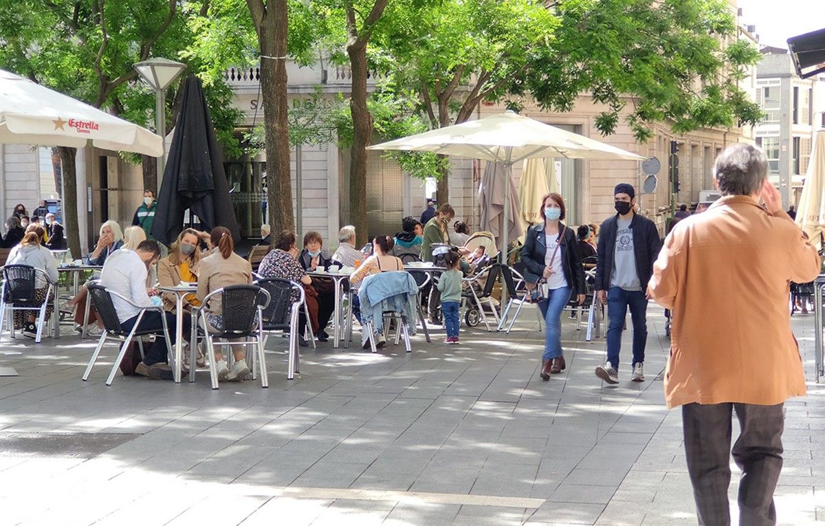 Gent passejant i a la terrassa d'un bar de Sabadell 