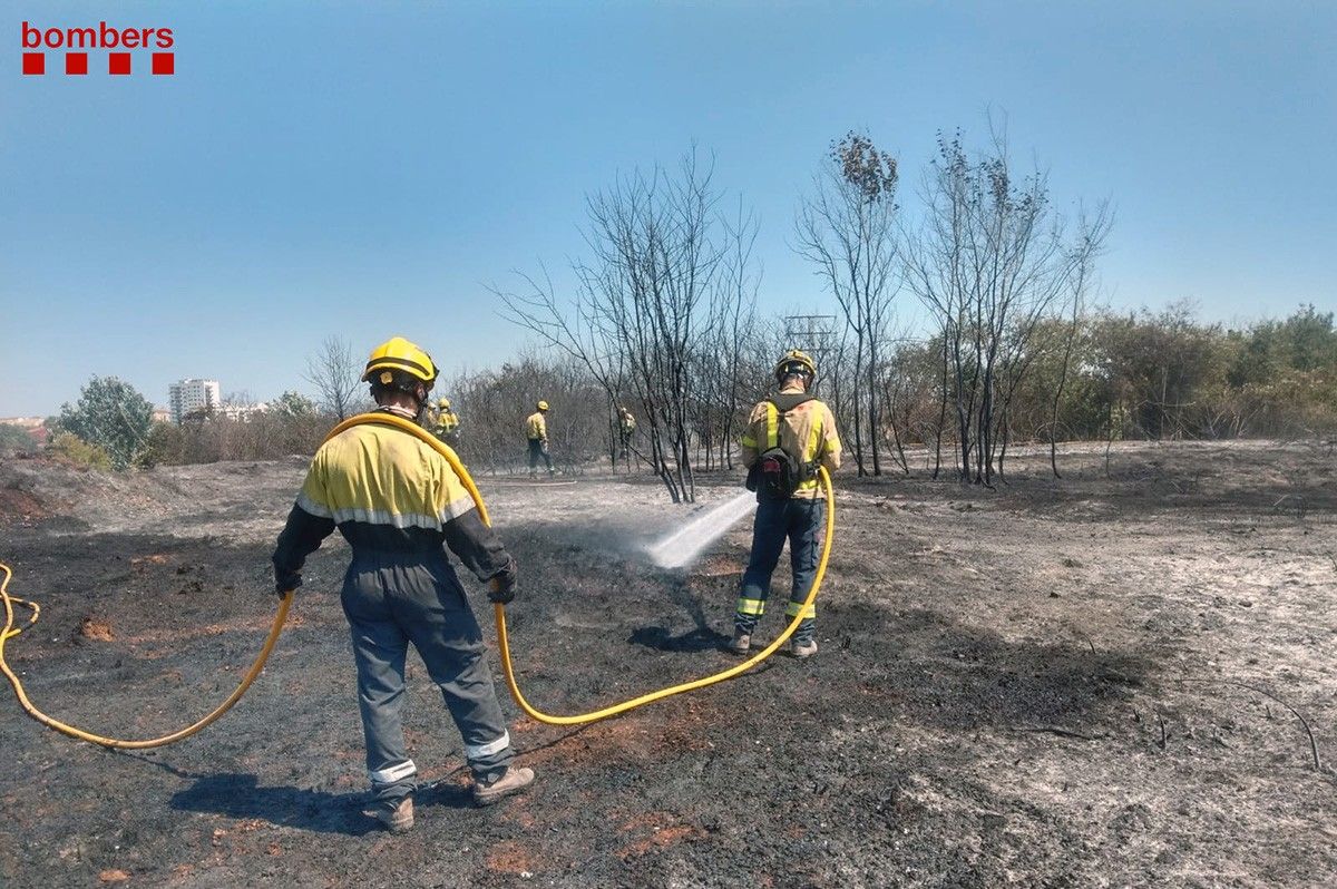 Els bombers treballant per apagar les flames 