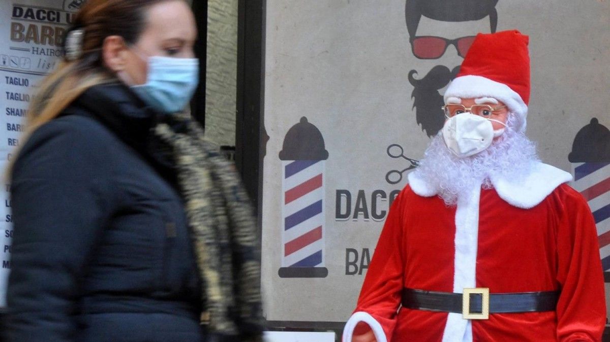 Una dona amb mascareta, davant d'un Pare Noel.