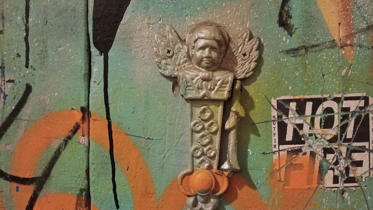 Picaporta en forma d'àngel en un edifici de Ciutat Vella, Barcelona