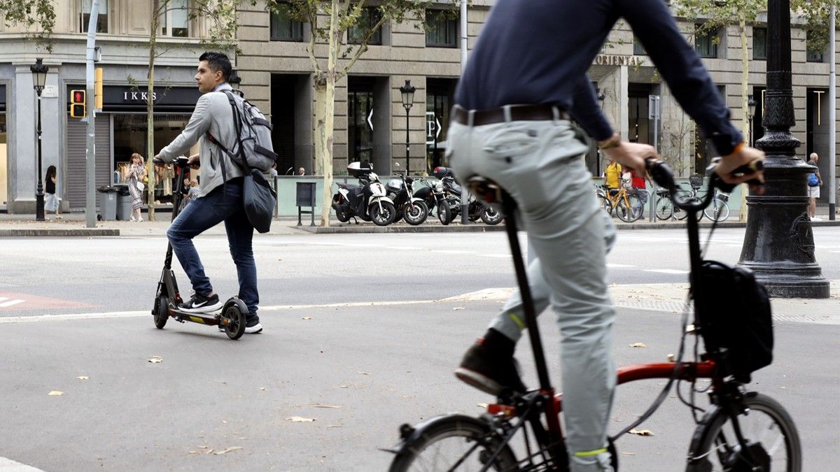 Un usuari de patinet elèctric espera per creuar al centre de Barcelona