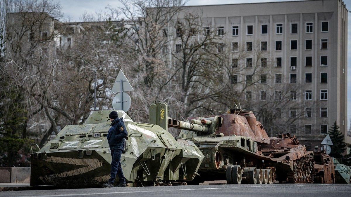 Un guàrdia de seguretat passa per davant de tancs russos destruïts