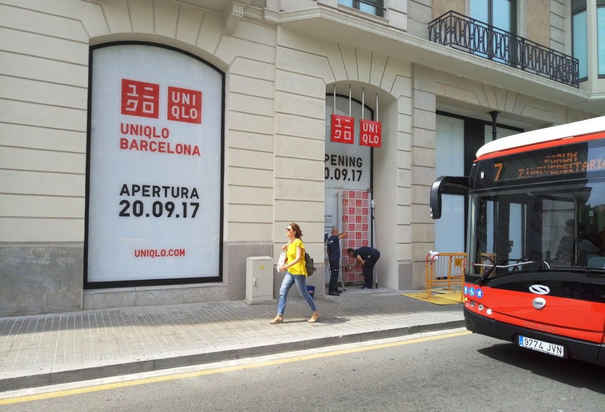 Uns operaris enllesteixen la botiga d'Uniqlo a Passeig de Gràcia