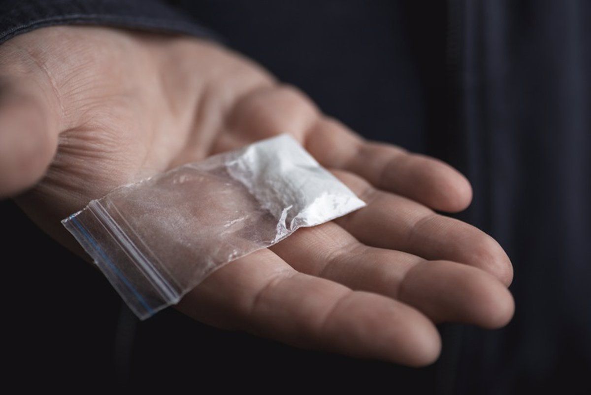 Un home amb un sobre de cocaïna a la mà