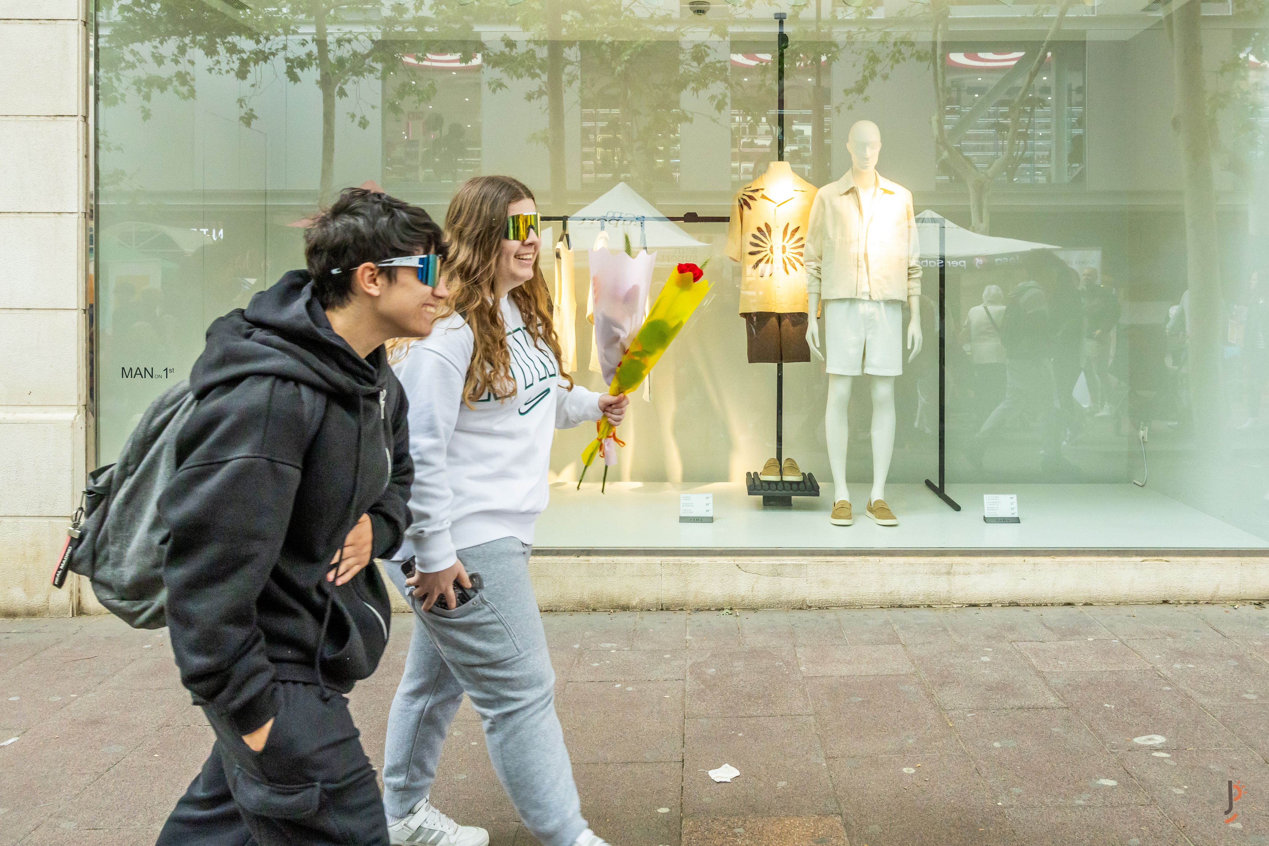 Una parella jove passeja per Sabadell amb les ulleres de sol a joc