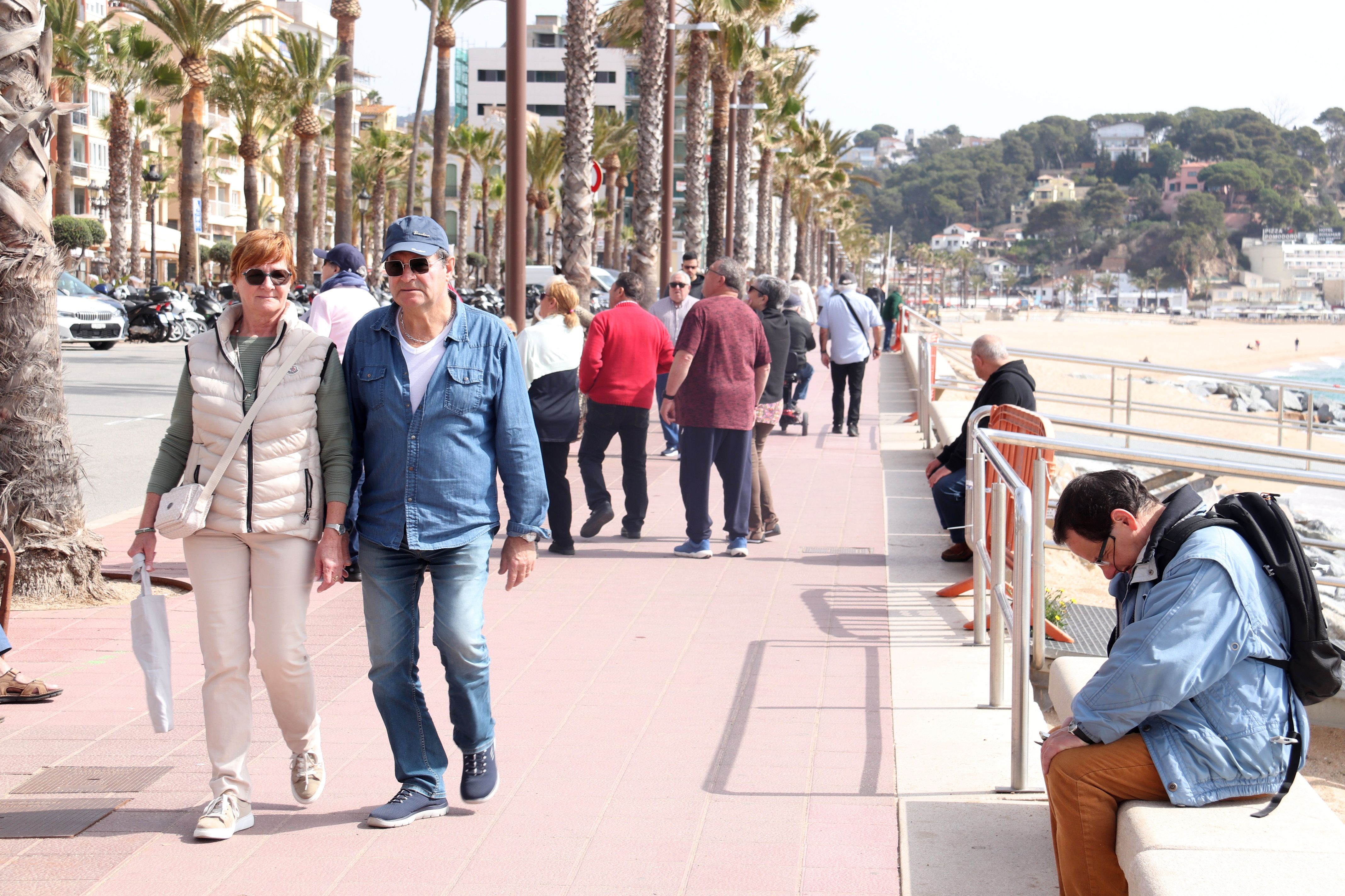 Alguns turistes passegen pel passeig marítim de Lloret de Mar a les portes de Setmana Santa